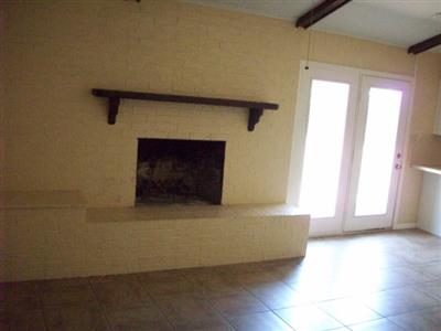 Den with Wood Burning Fireplace and Tile Floors